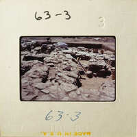 This is an image of an archaeological site with stone ruins and excavation equipment.