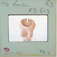 Image of a clay sculpture with a label and stamp on an envelope.