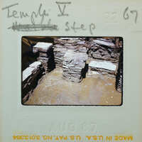 Excavated wall with visible layers and artifacts.