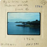 A vintage photograph showing a serene coastal scene with a body of water and an island.