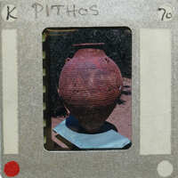 A photograph of a large, cracked clay pot on table.