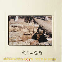 A photograph of an old stone wall with a dirt path leading up to it.