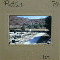 A photograph of a rocky landscape with trees and buildings, taken on September 71, 1974.