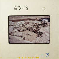 Ancient ruins with stone walls and dirt ground.