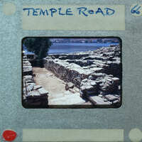 Parallel wall with surface between them and water in the background.