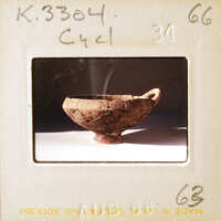 A photograph of an old, cracked clay bowl on a white surface.