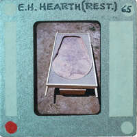 A photograph of a stone bed with a wooden frame, taken from an old Polaroid photo.