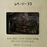 This is an image of a rock wall with a warning sign.