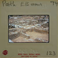 A photograph of an archaeological site with stone ruins and a dirt ground, taken on October 7, 1974.