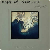 Aerial photo of a coastal area on a film strip labeled "KM17" with handwritten notes.