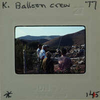 Old photograph of a balloon crew with mountains in the background.