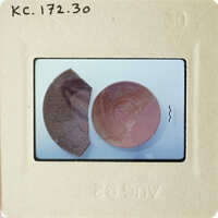 Two broken pottery shards on a white surface.