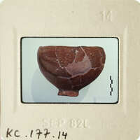 Cracked brown clay artifact on display.