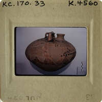 Ancient clay pot with intricate designs on display.