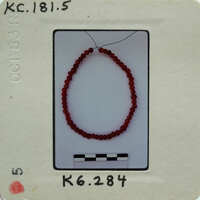 The image shows a red bead bracelet on a white background.