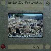 Old photo of a stone fort wall with trees and mountains in the background, encased in a vintage film strip holder.