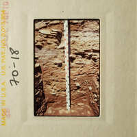 A ruler measuring the depth of an excavation site.