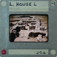 Old photograph of a dilapidated stone structure with handwritten label and numbers on the border.