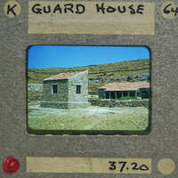 Picture of a stone building with a red roof, possibly a guard house, on a film strip.