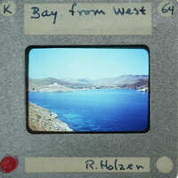 A vintage photograph of a scenic bay with mountains and water, enclosed within an old-fashioned film strip border.