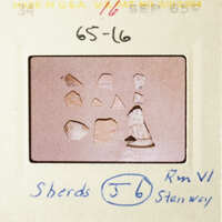 The photo shows a collection of small, irregularly shaped objects on a light background, with a handwritten note and numbers indicating their arrangement.