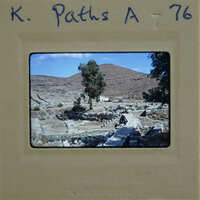 An old photo of ancient ruins with a tree and mountains in the background, labeled "K. Paths A 76".