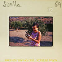 Woman holding a bird in her hand, smiling at the camera.