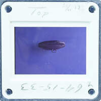 Round metal object with loop handle.