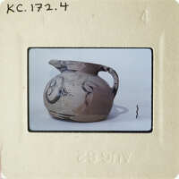 This is an image of a clay pot with markings on it, photographed against a white background.