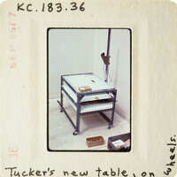 A metal workbench with shelves and tools on the floor.