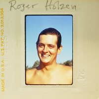 Man smiling at camera with no shirt on.