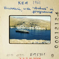 A photograph of an island with houses and boats on the water, taken from a high vantage point.