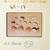 The photo shows a collection of small, broken objects on a table.