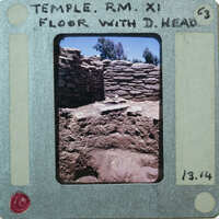 Stone walls with various surfaces and terracotta head on floor.