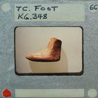 An old, worn-out shoe photographed on a film strip with a label that reads "TC KG 3467".