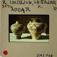 Two antique vases displayed on a table.
