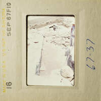 A photo of a destroyed building with rubble and debris, taken from an elevated angle.