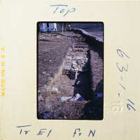 A photograph showing an excavation site with exposed stone and dirt, possibly indicating historical ruins.