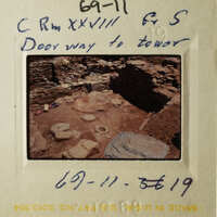 The photo shows an old slide with writing on it, depicting an archaeological site with ruins and a handwritten note.