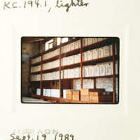 "A photograph showing an indoor room with numerous shelves filled with file folders."