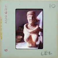 Terracotta figurine on workbench.