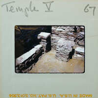 Excavated wall with visible layers and artifacts.