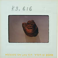 A photograph of a clay face mask on display.