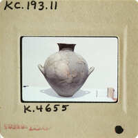 Ancient vase with cracks and chips on display.