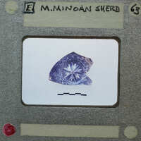 A close-up image of a small, worn object with a star-like design on it.