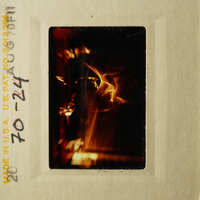 An old-fashioned photograph with an image of a fire inside a frame, possibly from a film strip.