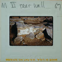 A photo of a rock wall with handwritten notes on the front and back.