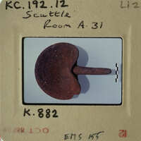 Old photograph of an object, possibly a tool or artifact, with visible wear and tear.