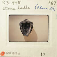 A photograph of an ancient stone tool, specifically a flint blade with a heart-shaped cross-section.