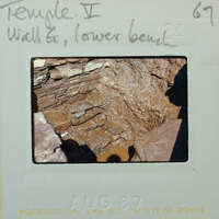 Stone walls and bench with a muddy floor.